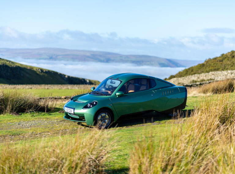 A green car in a field.