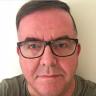 Head shot of journalist David Owens, wearing glasses.