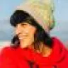 A woman in a red coat and a bobble hat.