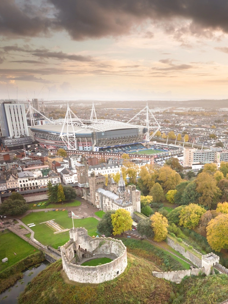 Vista aérea de una ciudad con un gran castillo, parque y estadio a la vista.