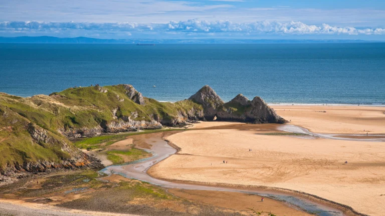 Bild der Three Cliffs Bay, aufgenommen von den Dünen aus mit Blick auf die Three Cliffs und das Meer.