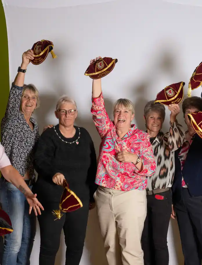 Group of women smiling and throwing their caps in the air.