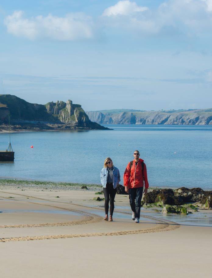 Paar, das allein am Strand spaziert, Caldey Island.
