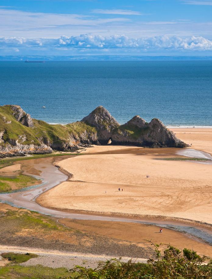 Image of Three Cliffs Bay taken from dunes looking out at the Three cliffs and the sea