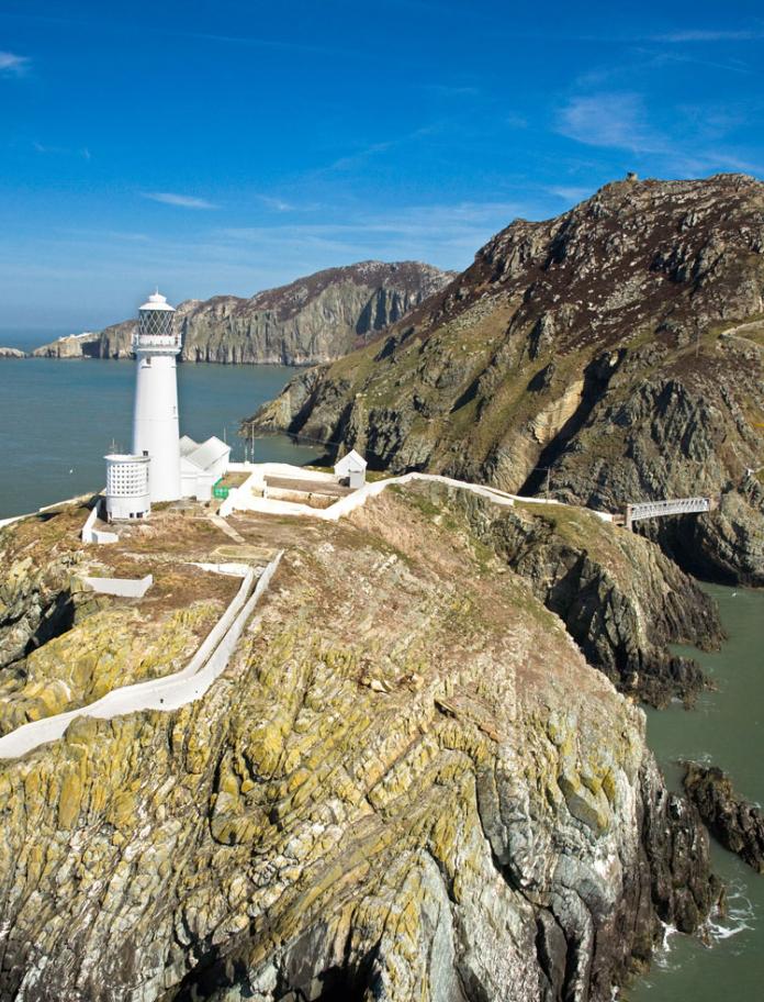 Aerial view of South Stack Lighthouse on mountains, surrounded by sea