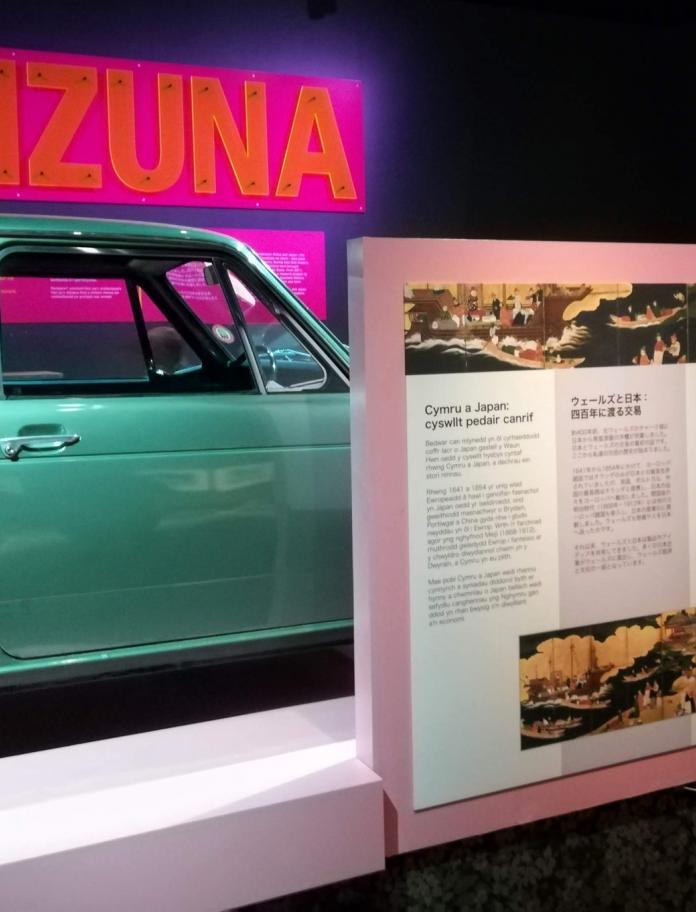 Ein grünes Auto und eine Infotafel in der Kizuna-Ausstellung