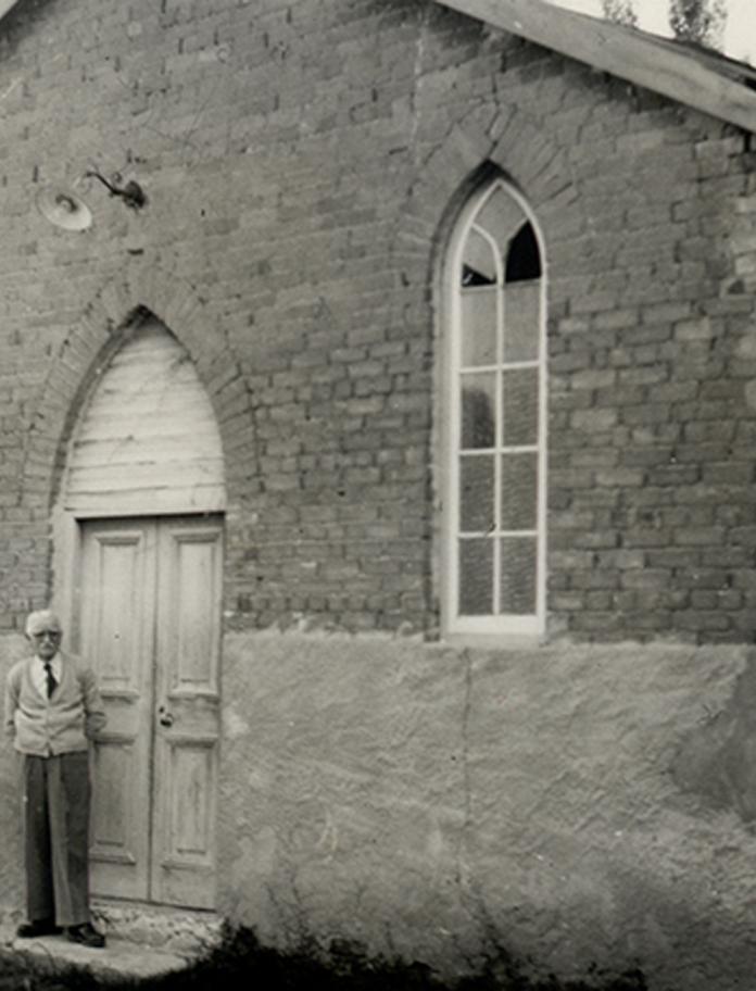 Man stood outside a chapel. 'Trelew 1955 - Capel Bryngwyn (E.T. Edmunds)'