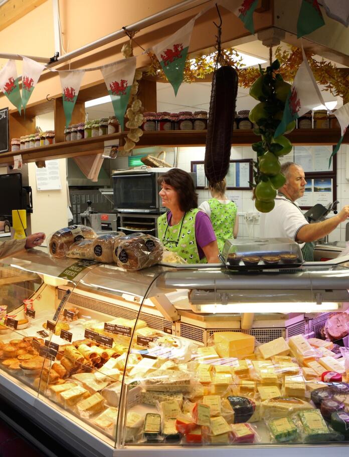 A woman buying cheese at a market stall.