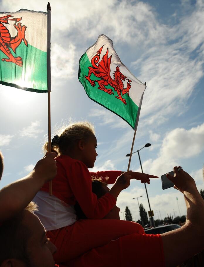 A group of people flying the Welsh flag.