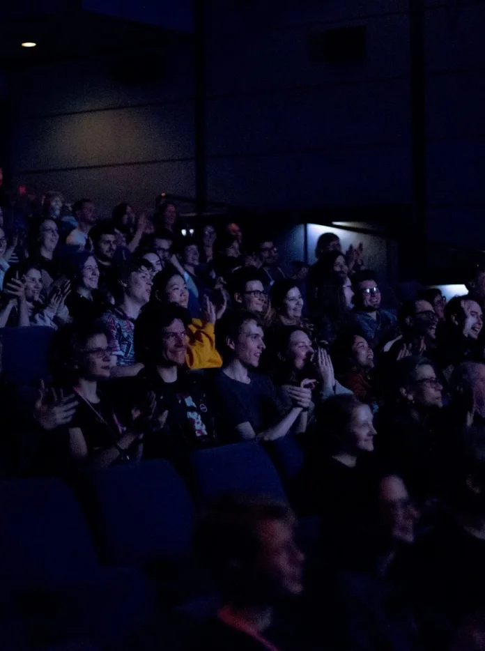 A crowd of people sat in a theatre.