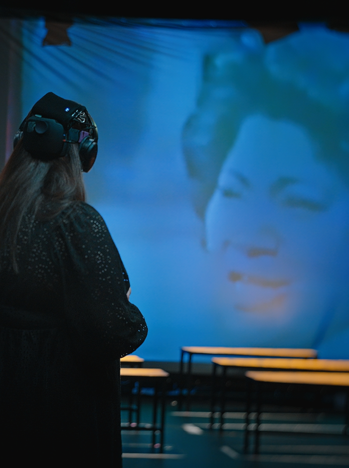 A person wearing headphones watching a show on screen