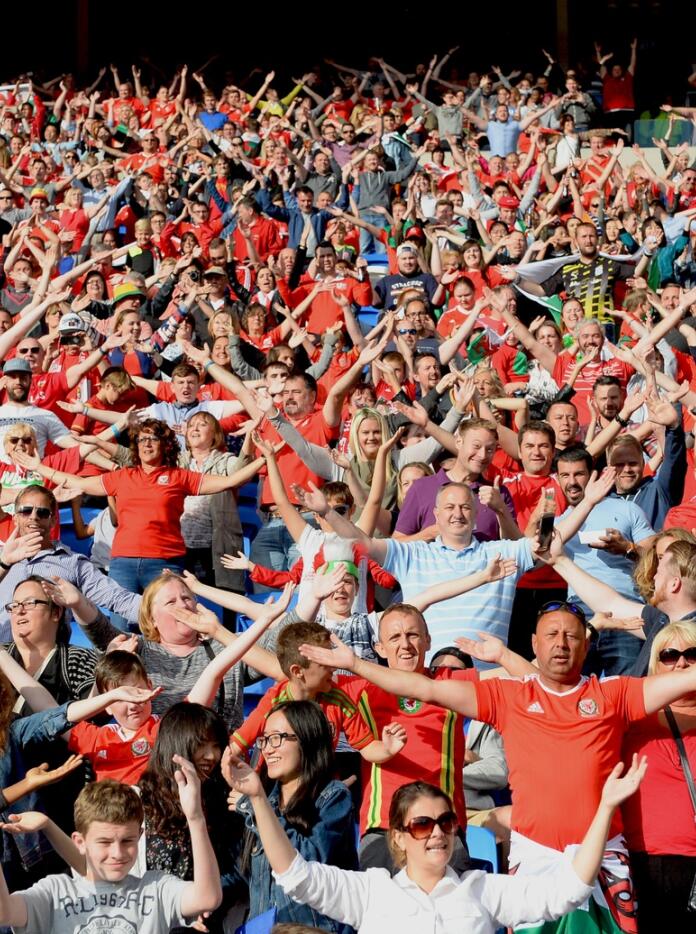 A crowd of people wearing red shirts at a football match.