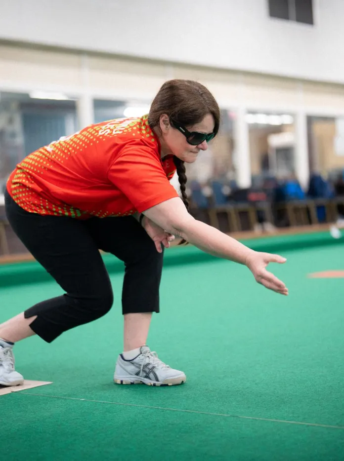 Julie Thomas delivering a bowl during an indoor Team Wales training session.