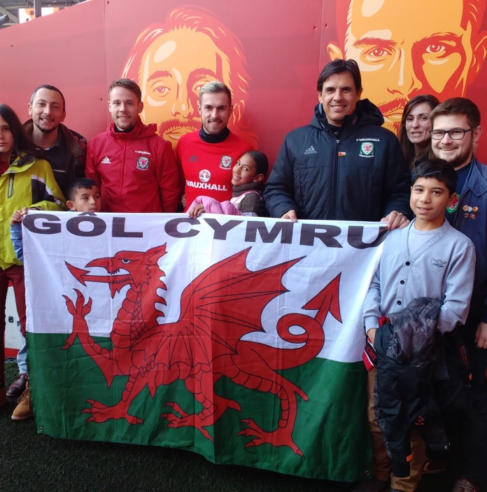 A group of people standing holding the flag.