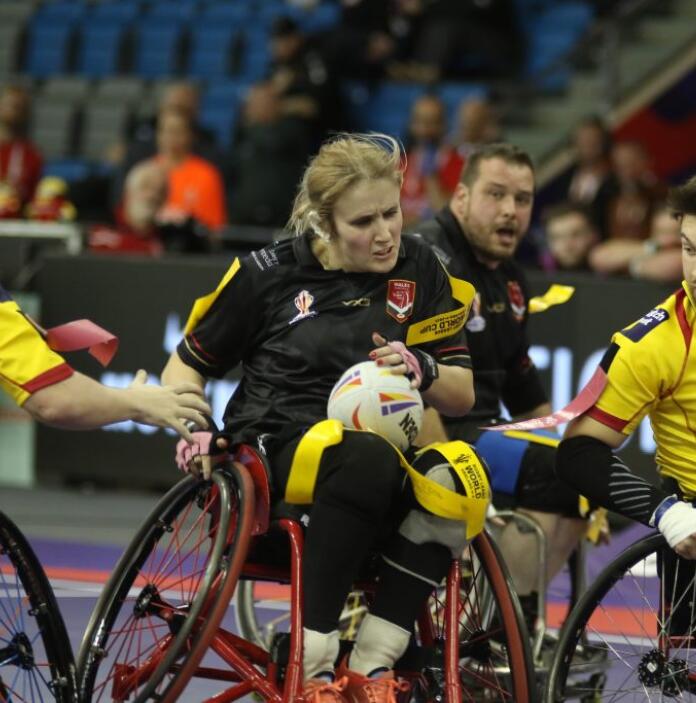 A woman and three men playing wheelchair rugby.