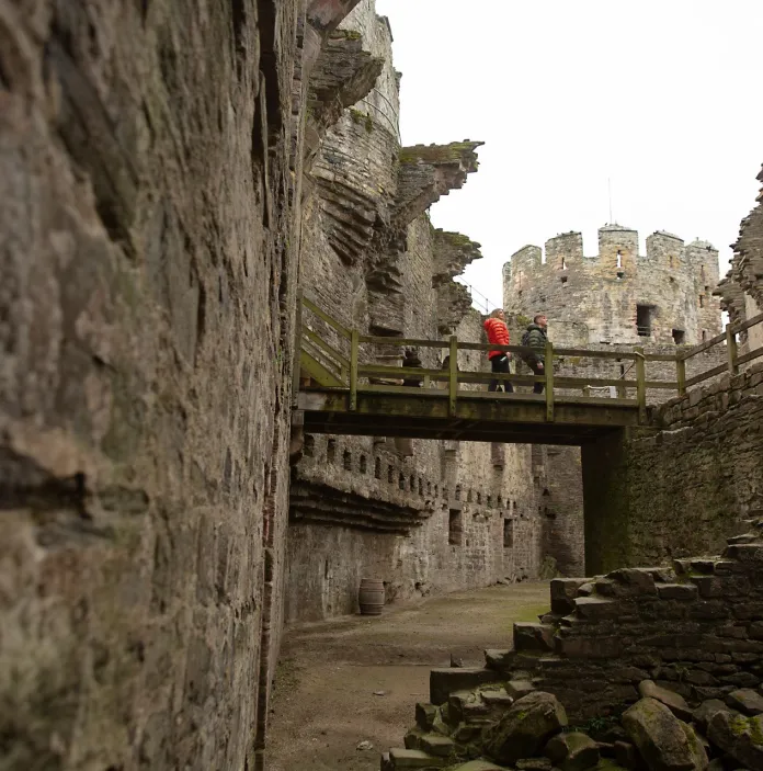 People walking over a bridge inside the castle.