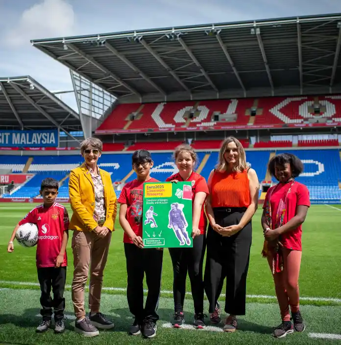 A group of people standing on the pitch at the stadium.