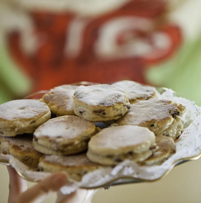 A plate of Welsh cakes with a Welsh flag in the background.