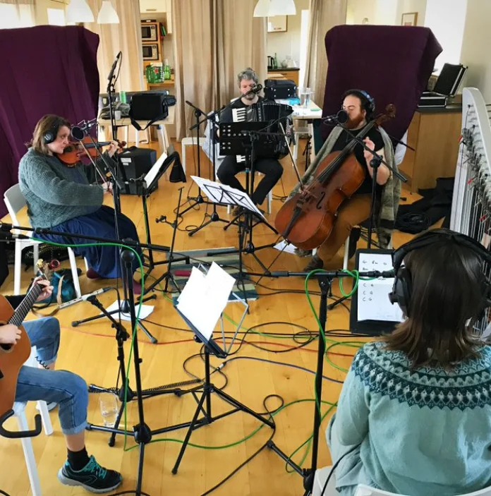Un groupe de musiciens jouant des instruments ensemble en cercle.