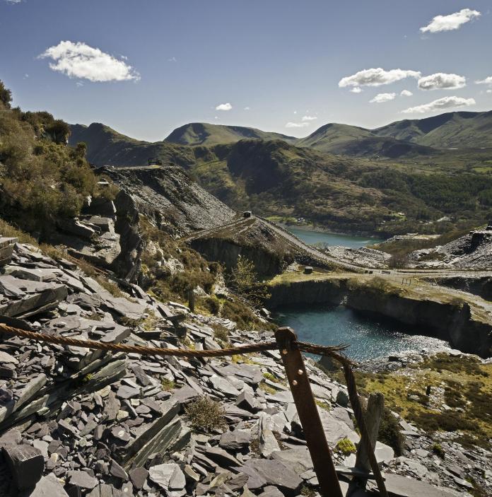 Old slate quarry with a lake within green mountains.
