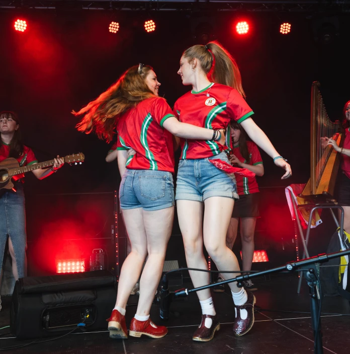 Two people dancing on a stage with a band playing music