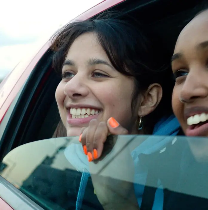 Two girls leaning out of a car window