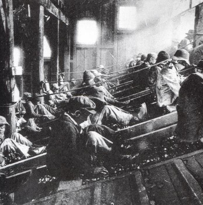 Black and white image of men working in a factory.