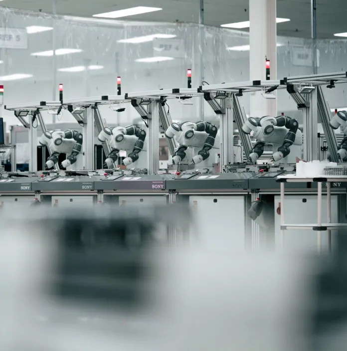 Robots alineados a lo largo de un banco de trabajo en un entorno técnico de fábrica impecable.