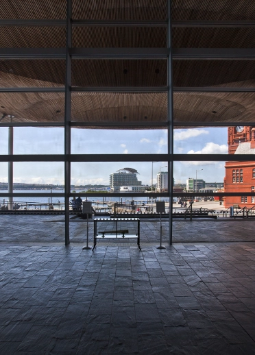 interior del edificio con piso de piedra y vista a través de la ventana a la bahía más allá.