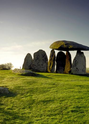 Megalithisches Monument bestehend aus mehreren gigantischen Steinen inmitten grüner Wiesen.
