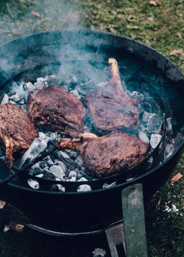 Lamb steaks frying in a pan.