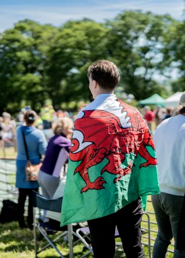 A spectator wearing a Welsh flag at the Man vs Horse race in Wales