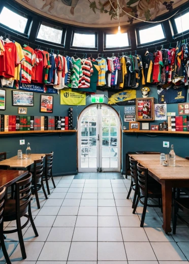 Seating area inside the Welsh Dragon Bar, with rugby shirts, flags and sporting memorabilia covering the walls. 