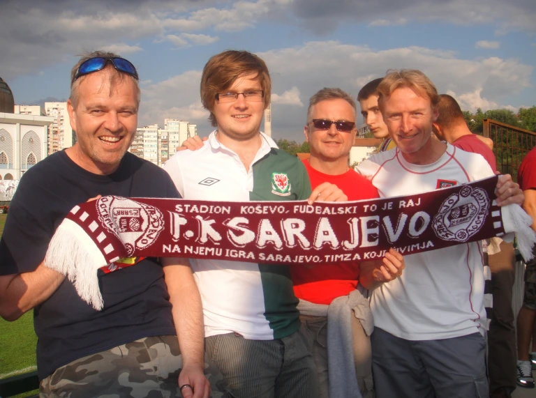 Four men holding a scarf.