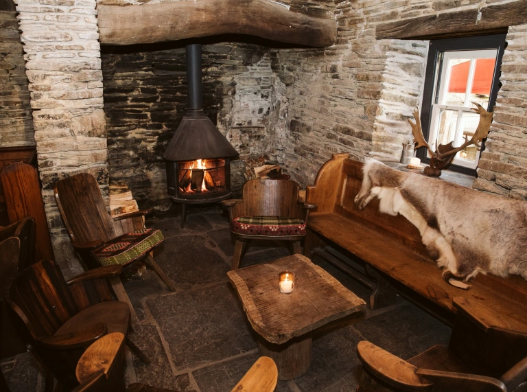 A cosy stone room with a fire.