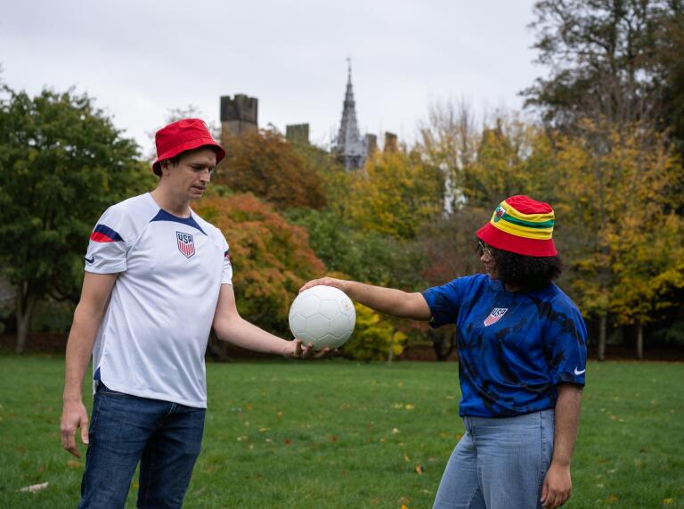 Two people holding a football together.
