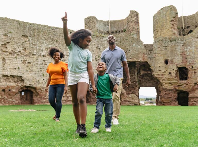 A family wandering through the ruins of an old castle