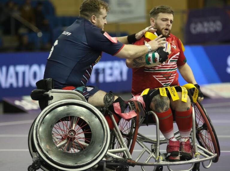 Two men in wheelchairs playing rugby.