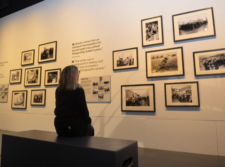 A person looking at a wall of photos in the museum