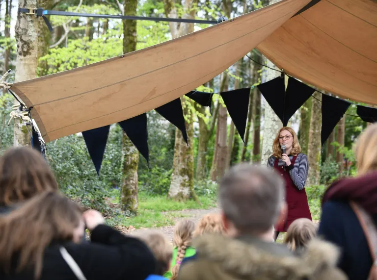 A comedian on the stage with an audience watching.