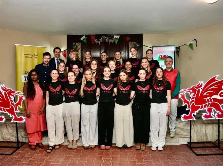Wales women's hockey team and supporters gather at a St David’s Day celebration in India.