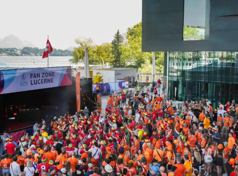 Crowd of football fans gathered outside the UEFA Women's EURO 2025 fan zone in Lucerne by the lakeside.
