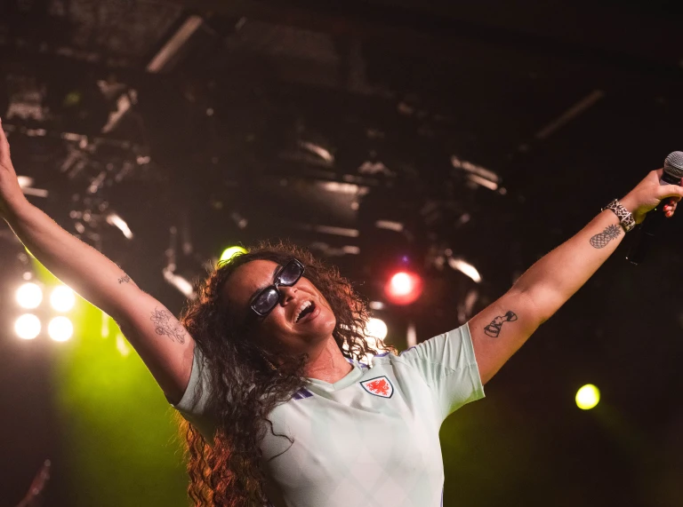 Singer Aleighcia Scott performs on stage for Cymru supporters during UEFA Women's EURO 2025 