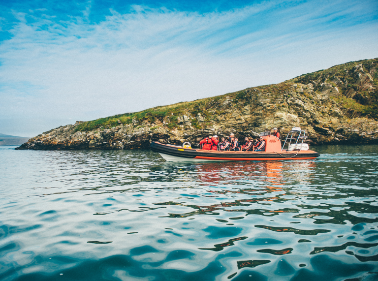 Boat of people at sea dolphin spotting off Ramsey Island, Pembrokeshire, South West Wales