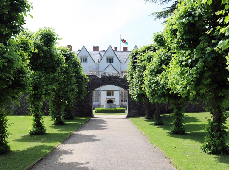 St Fagans National Museum of History, house shown through a tunnel of trees and arch
