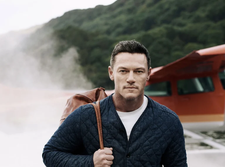 Luke Evans verlässt ein Kleinflugzeug mit Rauch hinter ihm