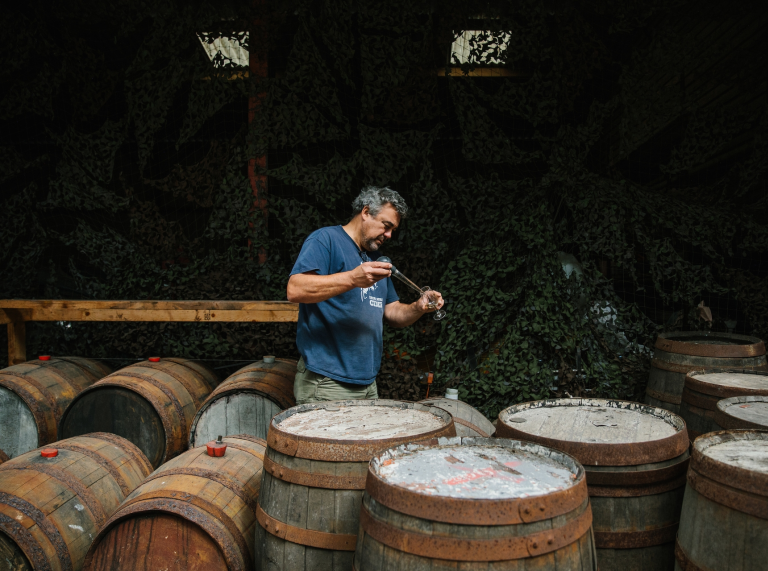 Andy Hallett tests cider from one of many barrels at Blaengawney Farm.