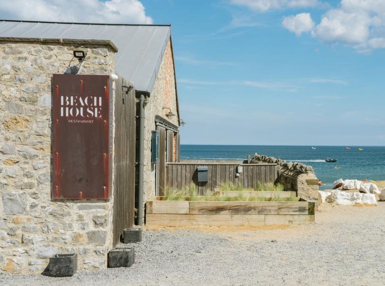 Extérieur du restaurant Beach House au Gower avec la mer en arrière-plan.