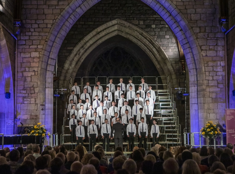 coro de niños bajo el arco cantando al público en la catedral.