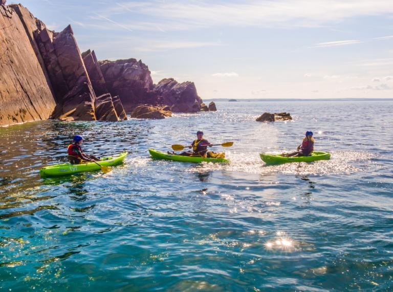 Group of people sea kayaking off the Pembrokeshire coast.